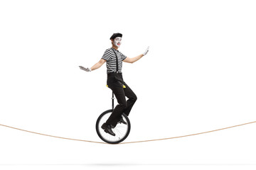 Mime riding a unicycle on a rope © Ljupco Smokovski