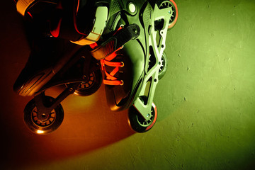 Close up view of roller skates inline skate or rollerblading on dark grunge background in neon blue...