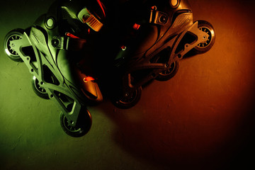 Close up view of roller skates inline skate or rollerblading on dark grunge background in neon blue...