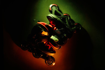 Close up view of roller skates inline skate or rollerblading on dark grunge background in neon blue...