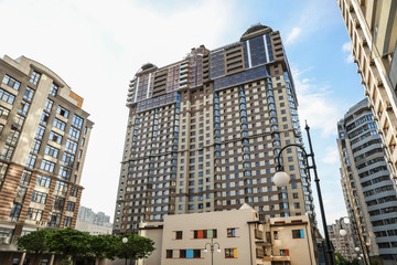 Fototapeta premium Modern buildings with tinted windows against sky. Urban architecture