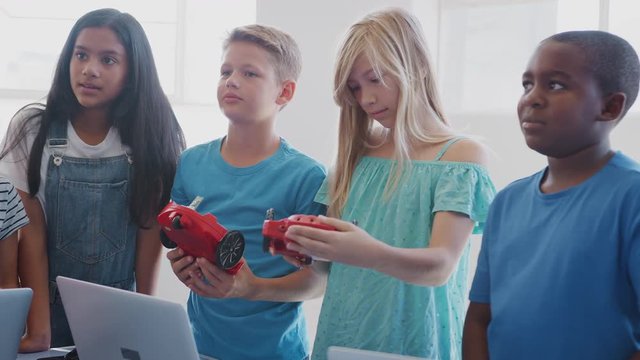 Group Of Students In After School Computer Coding Class Learning To Program Robot Vehicle