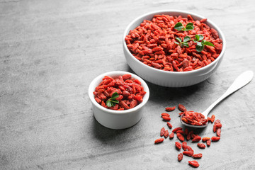 Composition with dried goji berries on grey table, space for text. Healthy superfood