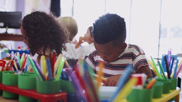 Group Of Elementary School Pupils Working At Desks Together