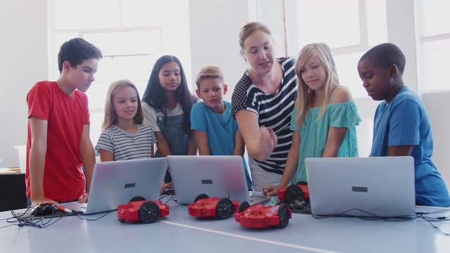 Excited Students Watching Robot Vehicle Move After Coding Lesson In Computer Programing Class