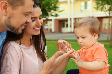 Happy family with adorable little baby outdoors