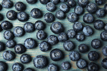 Fresh tasty blueberries on wooden table, flat lay