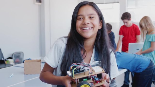 Portrait Of Female Student Holding Robot Vehicle In After School Computer Coding Class 