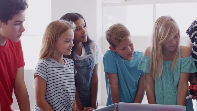 Students With Female Teacher In After School Computer Coding Class Learning To Build Robot Vehicle