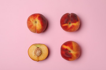 Sweet juicy peaches on pink background, top view