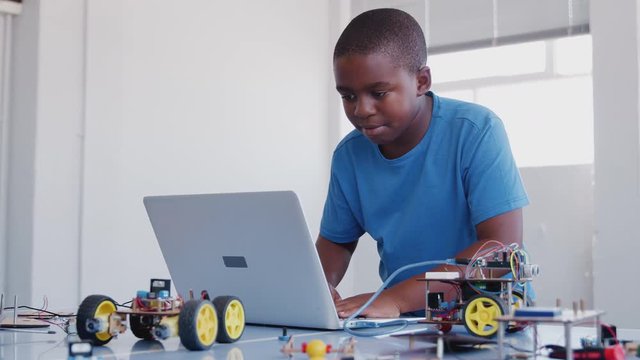 Male Student Building And Programing Robot Vehicle In After School Computer Coding Class 
