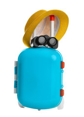 Stylish little blue suitcase with hat and binocular on white background
