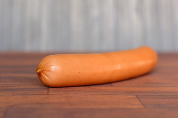 One single Vienna sausages on wooden table