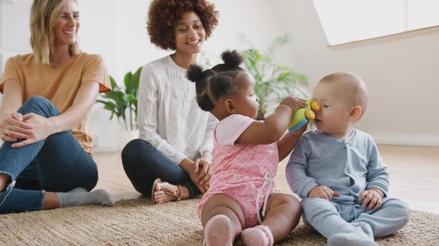 Two Mothers Meeting For Play Date With Babies At Home In Loft Apartment