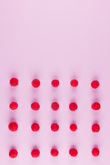 Pattern of raspberries on pink background. Colorful diet and healthy food concept. Background of raspberries. Top view. Flat lay. Copy space