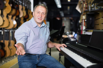 Smiling musician is playing on modern keyboard