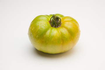 Tomate verde sobre fondo liso