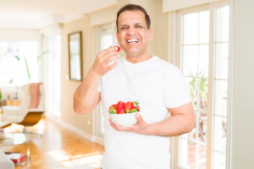 Middle age man eating strawberry at home