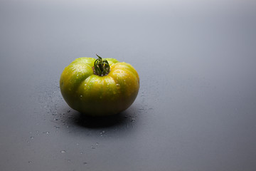 Tomate verde por madurar; tomate ecológico recién  traido del huerto