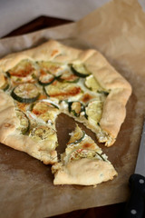 Homemade galette with zucchini and feta cheese. Selective focus.