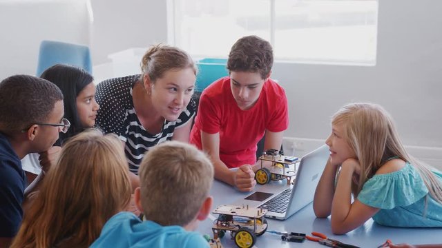 Students With Teachers In After School Computer Coding Class Learning To Program Robot Vehicle