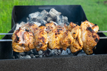 Marinated chicken kebab is cooked on the grill on the coals.