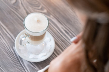 glass delicious beautiful latte coffee. girl is preparing to drink coffee.