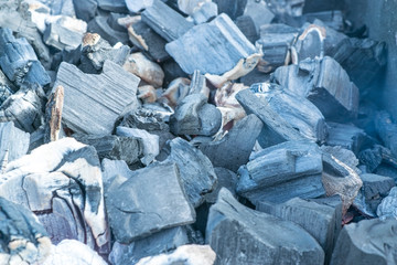 Barbecue grill with flaming and hot coal briquettes for barbecue, close-up