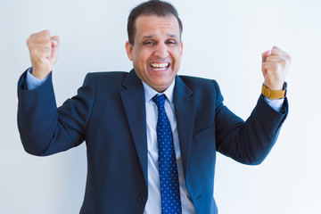 Middle age business man celebrating and screaming happy for succesful win