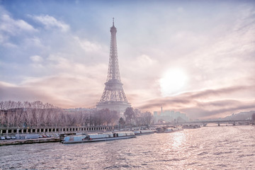 View of the Eiffel Tower, the main attraction of Paris from the Seine River embankment on a winter frosty evening, France