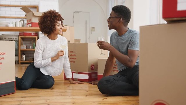 Couple Celebrating Moving Into New Home Making A Toast With Wine