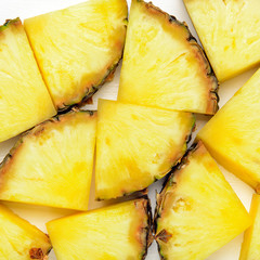 Pineapple Slices on white wooden background. Tropical juicy exotic healthy fruit texture. Top view, flat lay.