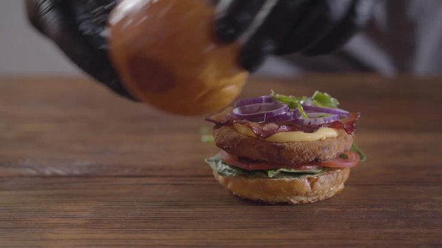 Hands of the chef making burger close-up. Tasty food preparation.