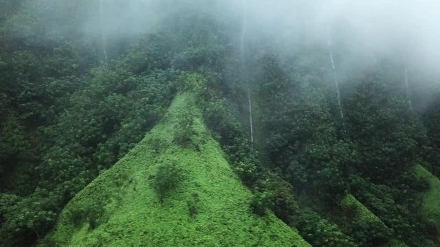 Cinematic Aerial of Amazing Waterfalls on Ridges After Heavy Rain Behind Clouds Under Haiku Stairs on Oahu Island, Hawaii