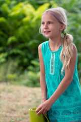 Fototapeta premium Little cute caucasian girl with a green mat goes to children's yoga in the Park. Healthy, exercise concept. Kids yoga concept. girl is practicing yoga. Healthy lifestyle. Yoga girl
