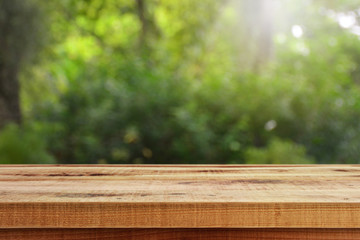 Blurred abstract green bokeh and wooden table background.