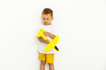 happy child toddler playing with yellow toy airplane