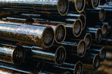 Naklejka premium Drilling of oil and gas wells. Drill pipe inspection. Tubing for oil and gas listed on the pedestal out of the wells after washing and ready for inspection. Stack of casing laying on the deck.