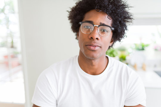 African American man wearing glasses Relaxed with serious expression on face. Simple and natural with crossed arms