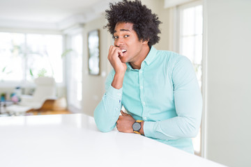 African American business man wearing elegant shirt looking stressed and nervous with hands on mouth biting nails. Anxiety problem.