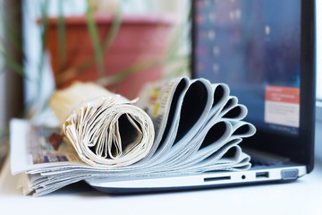 Newspapers and Laptop. Different Concepts for News -  Network or Traditional Tabloid Journals. Data...