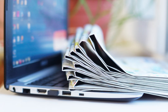 Newspapers and Laptop. Different Concepts for News -  Network or Traditional Tabloid Journals. Data Sources - Electronic Screen of Computer or Paper Pages of Magazines, Internet or Papers 