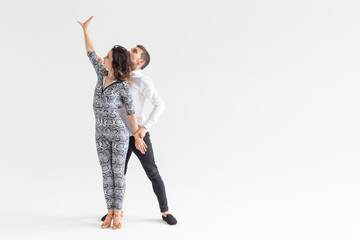 Skillful dancers performing in the white background with copy space. Sensual couple performing an...
