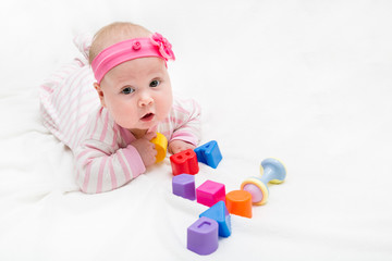 Cute baby playing with colorful toy. New born child, little girl looking at the camera and crawling. figure four of the toy cubes