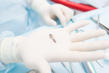 Dentist doctor holds dental implant 