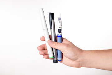 Hand holding insulin pen on isolated white background