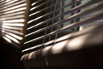 Close up of window blinds during sunset/sunrise, playful reflection