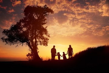 Fototapeta na wymiar Happy family silhouette standing on against sunset time