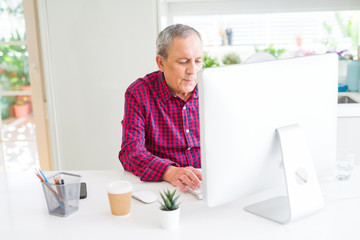 Handsome senior man working with computer looking concentrated