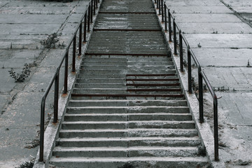 Obraz premium Old broken concrete staircase with metal handrails